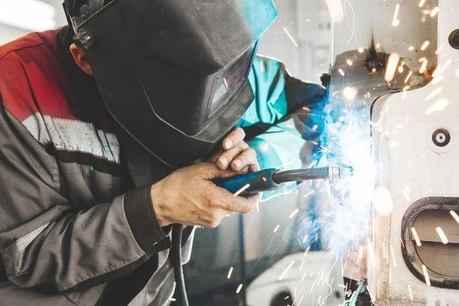 Industrial welder welds back bodywork of car
